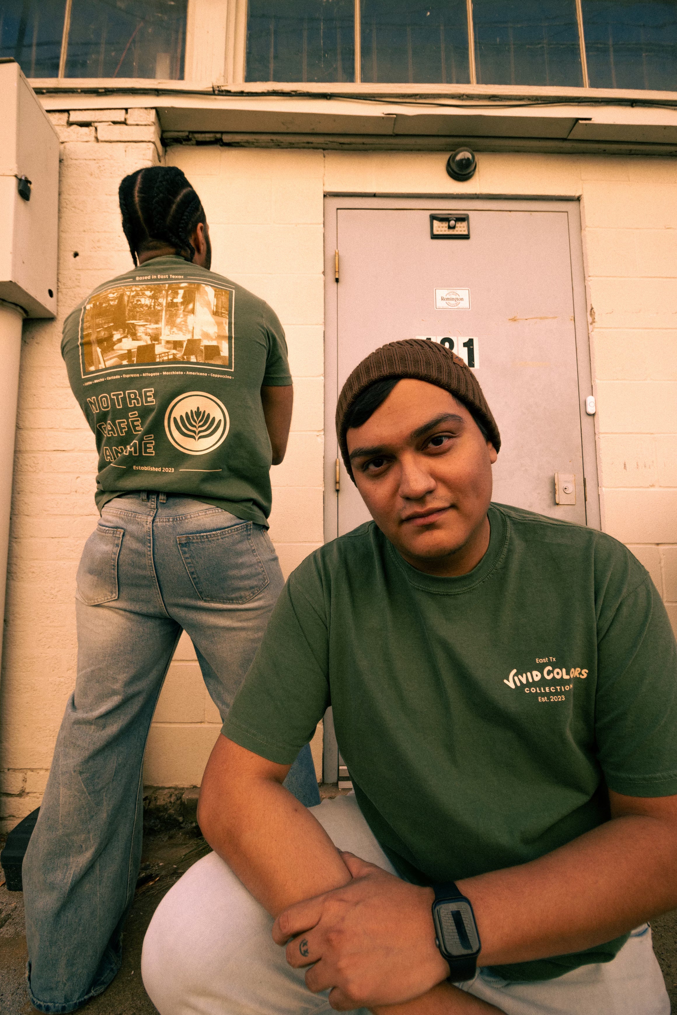 Two guys standing outside wearing the vivid colors cafe shirt